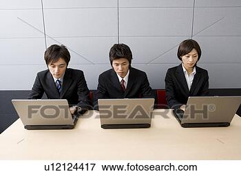Picture - three young business 
people using computers. 
fotosearch - search 
stock photos, 
pictures, images, 
and photo clipart
