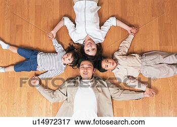 Picture - high angle view 
of a family lying 
on floor. fotosearch 
- search stock 
photos, pictures, 
images, and photo 
clipart