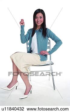 Stock Photo - young woman sitting 
on chair and raising 
one hand. fotosearch 
- search stock 
photos, pictures, 
images, and photo 
clipart