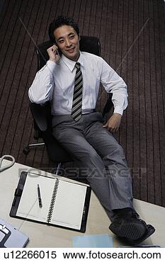 Stock Image - office man holding 
a mobile phone 
on chair. fotosearch 
- search stock 
photos, pictures, 
images, and photo 
clipart