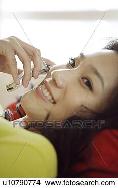 Stock Photo - young woman holding 
a cellphone and 
lying in bed. 
fotosearch - search 
stock photos, 
pictures, images, 
and photo clipart