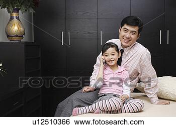 Stock Photo - father sitting 
with call-holding 
daughter. fotosearch 
- search stock 
photos, pictures, 
images, and photo 
clipart