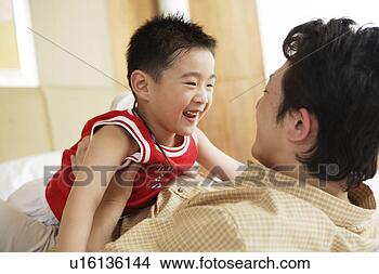 Stock Photo - young father and 
son playing in 
bed. fotosearch 
- search stock 
photos, pictures, 
images, and photo 
clipart