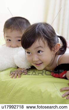 Stock Photo - boy and girl lying 
in bed, playing 
with dolls. fotosearch 
- search stock 
photos, pictures, 
images, and photo 
clipart