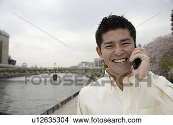 Stock Photo - a smiling young 
man using cellphone. 
fotosearch - search 
stock photos, 
pictures, images, 
and photo clipart