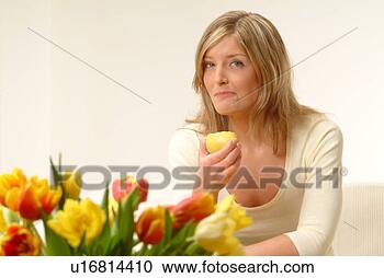 Stock Photography - woman eating apple, 
flowers in foreground. 
fotosearch - search 
stock photos, 
pictures, images, 
and photo clipart
