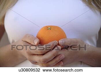 Stock Photo - woman holding 
whole orange, 
close up. fotosearch 
- search stock 
photos, pictures, 
images, and photo 
clipart