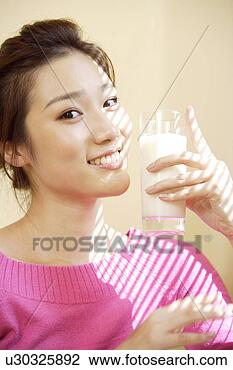 Stock Photo - young woman holding 
a cup of milk, 
smiling at camera. 
fotosearch - search 
stock photos, 
pictures, images, 
and photo clipart
