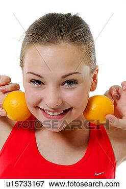 Picture - portrait of a 
young woman holding 
two oranges besides 
her two cheek. 
fotosearch - search 
stock photos, 
pictures, images, 
and photo clipart