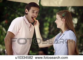 Stock Photo - woman feeding 
man a potato chip. 
fotosearch - search 
stock photos, 
pictures, images, 
and photo clipart