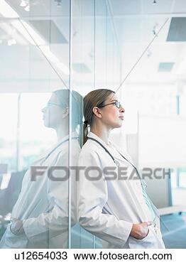 Stock Photo - concerned doctor 
leaning on glass 
wall in hospital 
lobby. fotosearch 
- search stock 
photos, pictures, 
images, and photo 
clipart