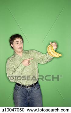 Stock Photography - portrait of caucasian 
teen boy holding 
and pointing at 
bananas. fotosearch 
- search stock 
photos, pictures, 
images, and photo 
clipart