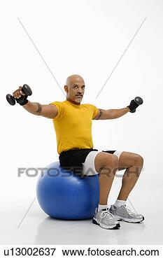 Picture - mid adult multiethnic 
man balancing 
on blue exercise 
ball with. fotosearch 
- search stock 
photos, pictures, 
images, and photo 
clipart