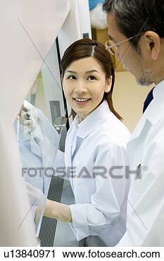 Stock Photography - two scientists 
talking in laboratory, 
 young woman injecting 
liquid. fotosearch 
- search stock 
photos, pictures, 
images, and photo 
clipart