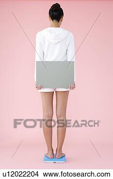 Banco de Imagem - mulher,  ficar, 
 banheiro,  escala, 
 segurando,  em 
branco,  painél. 
fotosearch - busca 
de fotos, imagens 
e clipart