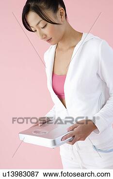 Foto - mulher,  segurando, 
 banheiro,  escala. 
fotosearch - busca 
de fotos, imagens 
e clipart
