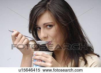 Banco de Imagem - jovem,  mulher, 
 comer,  iogurte. 
fotosearch - busca 
de fotos, imagens 
e clipart