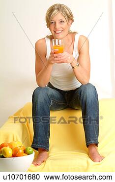 Arquivo de Fotografias - mulher,  sofá, 
 bebendo,  suco. 
fotosearch - busca 
de fotos, imagens 
e clipart
