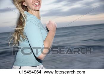 Banco de Imagem - jovem,  loura, 
 mulher,  sacudindo, 
 praia,  lado, 
 vista. fotosearch 
- busca de fotos, 
imagens e clipart