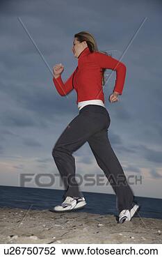 Stock Photo - young woman jogging 
at the beach, 
full length, side 
view. fotosearch 
- search stock 
photos, pictures, 
images, and photo 
clipart