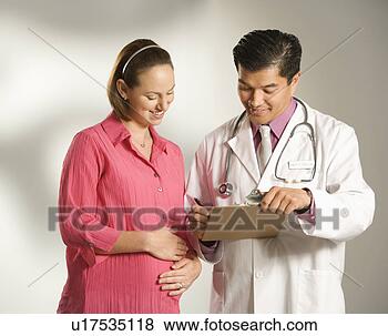 Stock Photo - asian american 
male doctor consulting 
with pregnant 
caucasian woman. 
fotosearch - search 
stock photos, 
pictures, images, 
and photo clipart