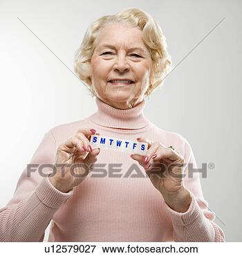 Picture - caucasian senior 
woman holding 
pill box and smiling 
at viewer. fotosearch 
- search stock 
photos, pictures, 
images, and photo 
clipart