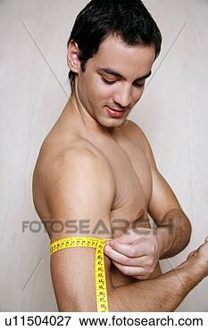 Picture - man measuring 
his arm muscle. 
fotosearch - search 
stock photos, 
pictures, images, 
and photo clipart