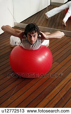 Stock Photo - young man performing 
a pilates exercise. 
fotosearch - search 
stock photos, 
pictures, images, 
and photo clipart