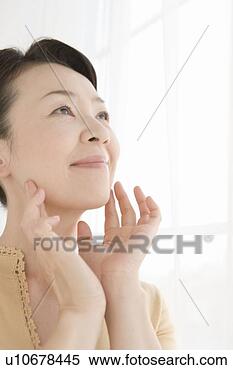 Stock Image - closed up image 
of a mature adult 
woman caring her 
skin condition. 
fotosearch - search 
stock photos, 
pictures, images, 
and photo clipart