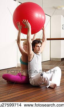Stock Photo - young man and 
woman performing 
a pilates exercise. 
fotosearch - search 
stock photos, 
pictures, images, 
and photo clipart