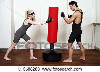 Stock Photo - young man and 
woman practicing 
with a punching 
bag. fotosearch 
- search stock 
photos, pictures, 
images, and photo 
clipart