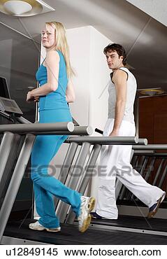 Stock Image - young woman and 
man on treadmill. 
fotosearch - search 
stock photos, 
pictures, images, 
and photo clipart