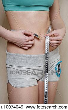 Stock Photograph - woman measuring 
her waist. fotosearch 
- search stock 
photos, pictures, 
images, and photo 
clipart