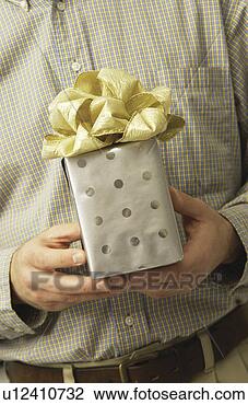Stock Photo - man holding a 
gift. fotosearch 
- search stock 
photos, pictures, 
images, and photo 
clipart