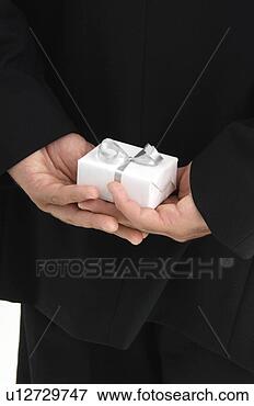 Foto - homem,  segurando, 
 presente,  atrás 
de,  seu,  costas. 
fotosearch - busca 
de fotos, imagens 
e clipart