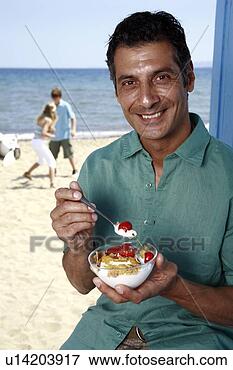 Foto - macho,  maduras, 
 comer,  pequeno 
almoço,  praia. 
fotosearch - busca 
de fotos, imagens 
e clipart