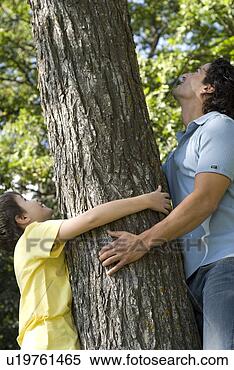 Stock Image - man and boy hold 
trunk of tree, 
looking upward, 
winipeg, canada. 
fotosearch - search 
stock photos, 
pictures, images, 
and photo clipart