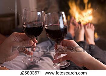 Stock Photography - feet warming at 
fireplace with 
hands holding 
wine. fotosearch 
- search stock 
photos, pictures, 
images, and photo 
clipart