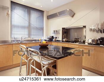 Stock Photography of Metal stools at breakfast bar on island unit ...