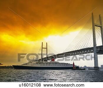 Stock Photo - the yokohama bay 
bridge by sunset 
and a huge boat 
cruising,  side. 
fotosearch - search 
stock photos, 
pictures, images, 
and photo clipart