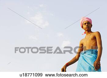 Stock Photograph - low angle view 
of a young man 
looking sideways. 
fotosearch - search 
stock photos, 
pictures, images, 
and photo clipart
