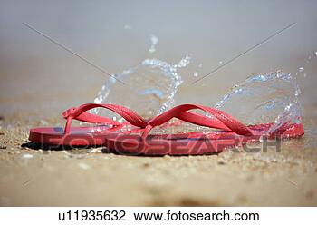 Stock Photo - flip flops on 
the beach with 
water splashing. 
fotosearch - search 
stock photos, 
pictures, images, 
and photo clipart