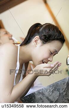 Stock Photo - side view of a 
young woman cleaning 
face in a wash 
basin. fotosearch 
- search stock 
photos, pictures, 
images, and photo 
clipart