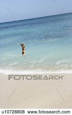 Stock Photo - view of a woman 
standing in sea 
water with hands 
raised. fotosearch 
- search stock 
photos, pictures, 
images, and photo 
clipart
