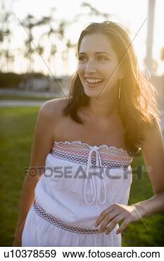 Stock Photograph - young adult woman 
smiling on grass, 
front view, differential 
focus. fotosearch 
- search stock 
photos, pictures, 
images, and photo 
clipart