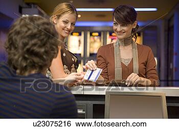 Stock Photo - women buying movie 
tickets at the 
box office. fotosearch 
- search stock 
photos, pictures, 
images, and photo 
clipart