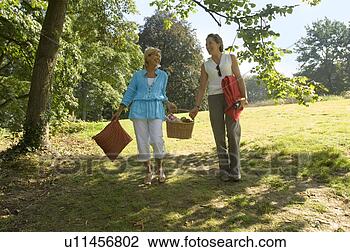 Stock Photo - two women carrying 
a picnic basket. 
fotosearch - search 
stock photos, 
pictures, images, 
and photo clipart