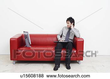 Stock Photo - businessman sitting 
on a couch and 
looking at computer 
monitor. fotosearch 
- search stock 
photos, pictures, 
images, and photo 
clipart