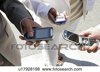 Banco de Imagem - três,  pessoas, 
 segurando,  seu, 
 cellphones. fotosearch 
- busca de fotos, 
imagens e clipart
