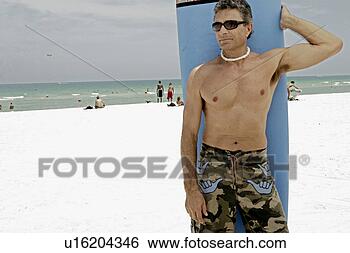 Stock Photo - view of a man 
holding a surfboard. 
fotosearch - search 
stock photos, 
pictures, images, 
and photo clipart